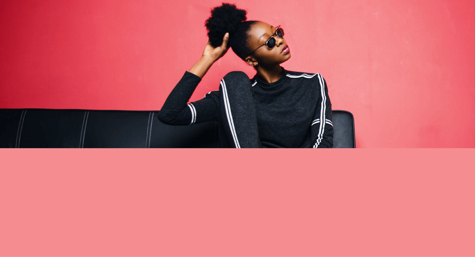 Modelo feminina vestindo blusa preta em fundo salmão