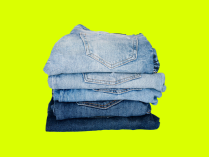 Quatro calças jeans dobradas e organizadas uma acima da outra, em fundo verde limão
